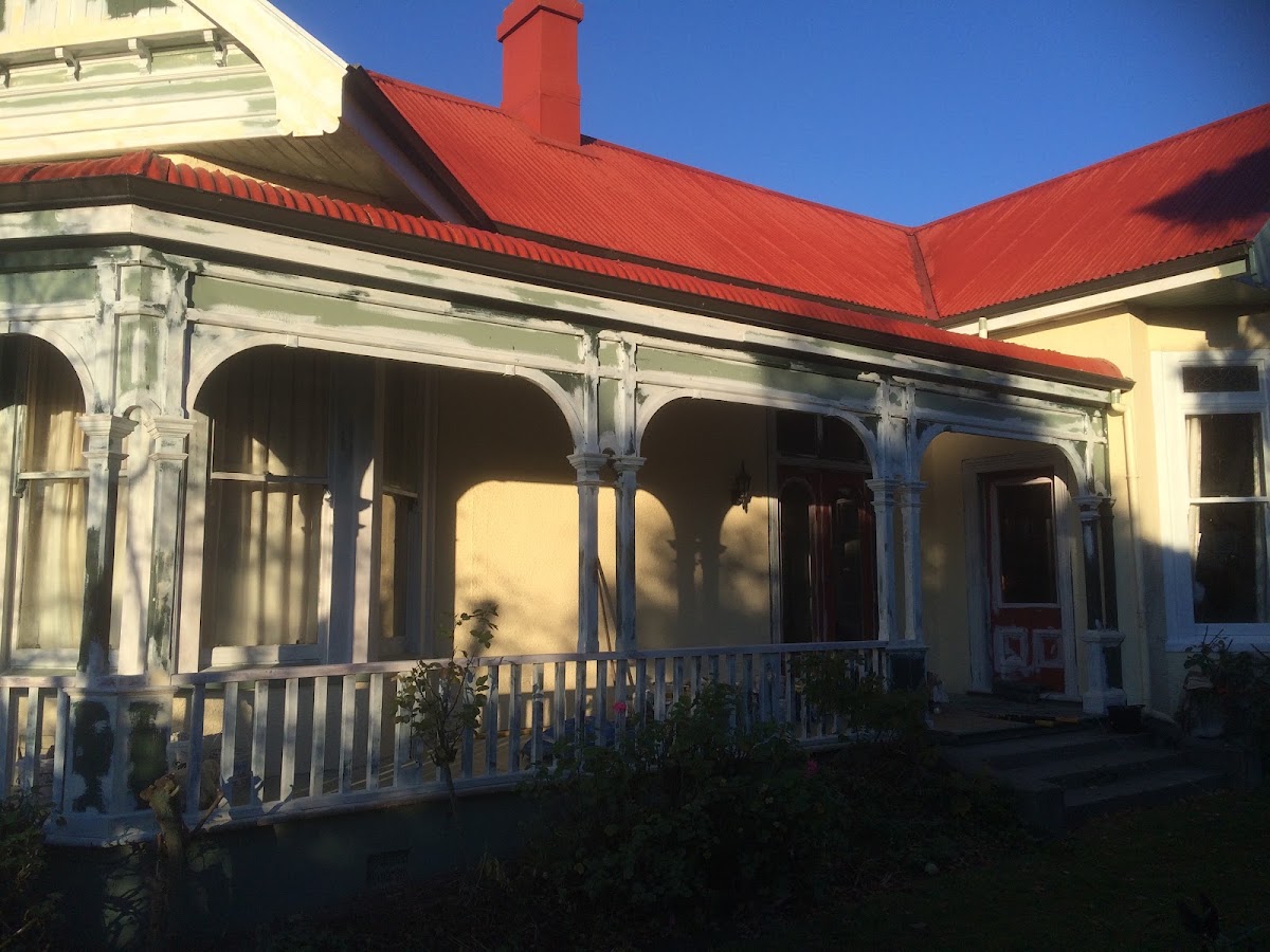 Heritage villa with red roof and arched veranda mid restoration