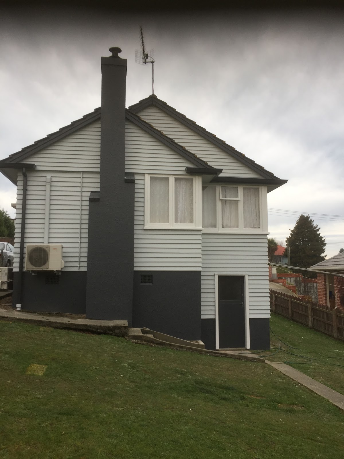 Repainted weatherboard bungalow exterior in two tone grey and white